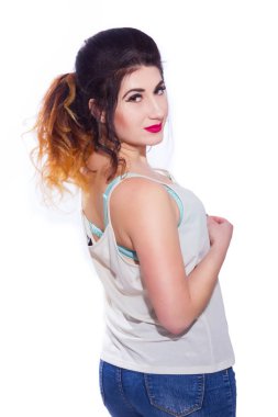 Stüdyo portre siyah saçlı güzel bir genç kadının bir kuyrukta toplandı. Kız beyaz bir arka plan karşı bir T-shirt ve jeans teşkil etmektedir. Kameraya bakıyor. İzole