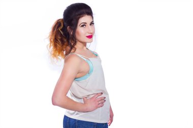 Stüdyo portre siyah saçlı güzel bir genç kadının bir kuyrukta toplandı. Kız beyaz bir arka plan karşı bir T-shirt ve jeans teşkil etmektedir. Kameraya bakıyor. İzole