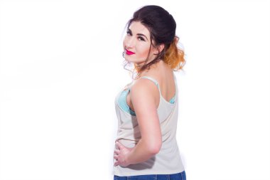 Stüdyo portre siyah saçlı güzel bir genç kadının bir kuyrukta toplandı. Kız beyaz bir arka plan karşı bir T-shirt ve jeans teşkil etmektedir. Kameraya bakıyor. İzole