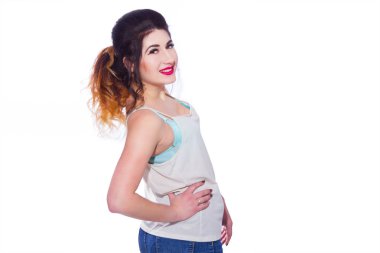 Stüdyo portre siyah saçlı güzel bir genç kadının bir kuyrukta toplandı. Kız beyaz bir arka plan karşı bir T-shirt ve jeans teşkil etmektedir. Kameraya bakıyor. İzole