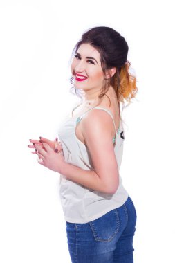 Stüdyo portre siyah saçlı güzel bir genç kadının bir kuyrukta toplandı. Kız beyaz bir arka plan karşı bir T-shirt ve jeans teşkil etmektedir. Kameraya bakıyor. İzole