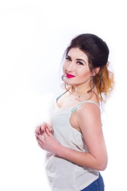 Stüdyo portre siyah saçlı güzel bir genç kadının bir kuyrukta toplandı. Kız beyaz bir arka plan karşı bir T-shirt ve jeans teşkil etmektedir. Kameraya bakıyor. İzole