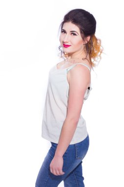 Stüdyo portre siyah saçlı güzel bir genç kadının bir kuyrukta toplandı. Kız beyaz bir arka plan karşı bir T-shirt ve jeans teşkil etmektedir. Kameraya bakıyor. İzole