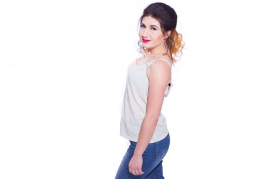 Stüdyo portre siyah saçlı güzel bir genç kadının bir kuyrukta toplandı. Kız beyaz bir arka plan karşı bir T-shirt ve jeans teşkil etmektedir. Kameraya bakıyor. İzole