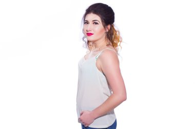 Stüdyo portre siyah saçlı güzel bir genç kadının bir kuyrukta toplandı. Kız beyaz bir arka plan karşı bir T-shirt ve jeans teşkil etmektedir. Kameraya bakıyor. İzole