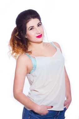 Stüdyo portre siyah saçlı güzel bir genç kadının bir kuyrukta toplandı. Kız beyaz bir arka plan karşı bir T-shirt ve jeans teşkil etmektedir. Kameraya bakıyor. İzole