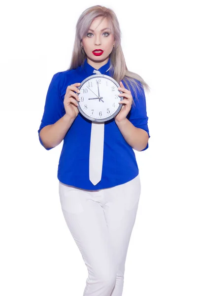 工作室商业肖像一个美丽的年轻金发女郎在深蓝色衬衫 白色长裤和白色领带 那个女孩拿着一个钟 复制空间 — 图库照片