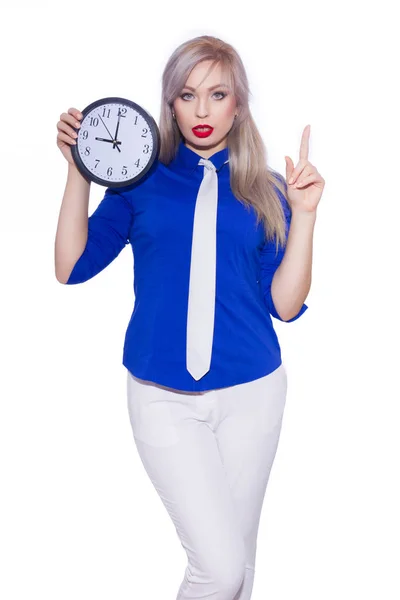 工作室商业肖像一个美丽的年轻金发女郎在深蓝色衬衫 白色长裤和白色领带 那个女孩拿着一个钟 复制空间 — 图库照片