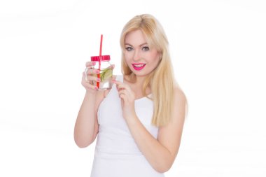 Dostça bir sarışın kadın bir bardak su ve kireç onun elinde tutar. Bir kız limonata içiyor. Kavram - sağlıklı gıda, yaz aylarında Şoklama susuzluk