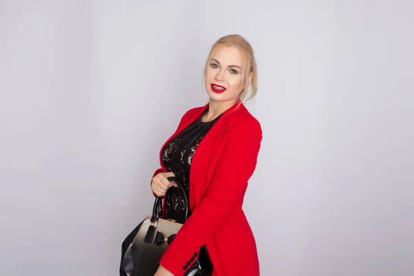 Business woman in red jacket holding bag in her hands — Stock Photo, Image