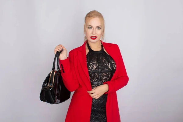 Mujer de negocios con chaqueta roja sosteniendo bolsa en sus manos —  Fotos de Stock