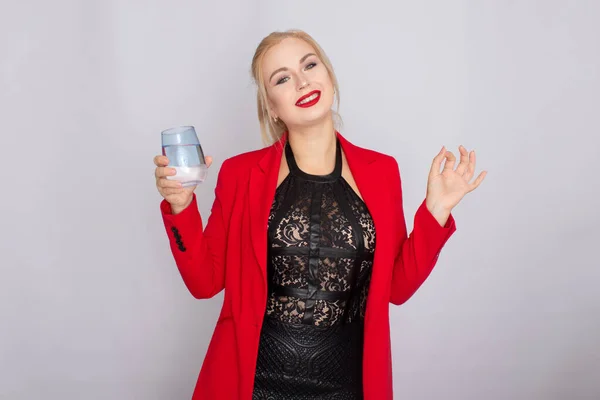 Mujer rubia sosteniendo vaso de agua sobre fondo claro —  Fotos de Stock