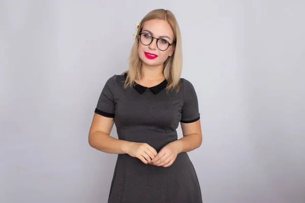 Junge blonde Frau im grauen kurzen Kleid mit Brille — Stockfoto