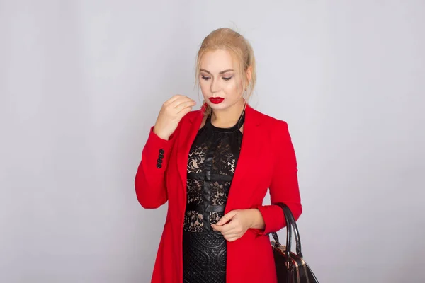 Mulher de negócios em casaco vermelho segurando saco em suas mãos — Fotografia de Stock