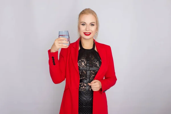 Mujer rubia sosteniendo vaso de agua sobre fondo claro —  Fotos de Stock