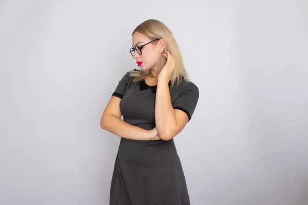 Mujer rubia joven en vestido corto gris con gafas — Foto de Stock