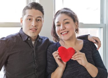 Sarılma ve Sevgililer günü içinde tutmak kalp oyuncak aşıkların güzel Latin çift çift büyük pencere poz