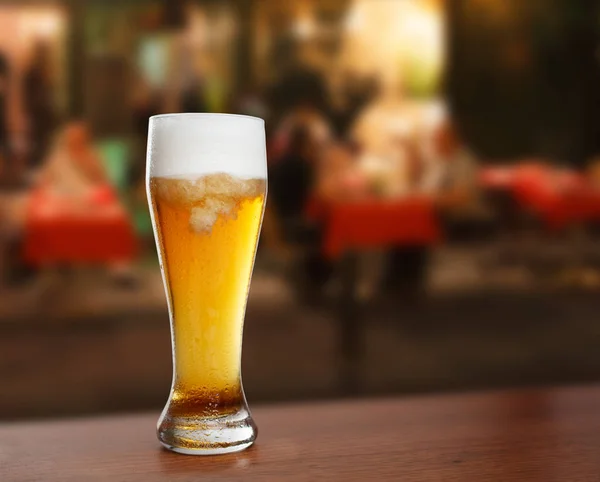 cold glass with beer on the background of a outside bar.