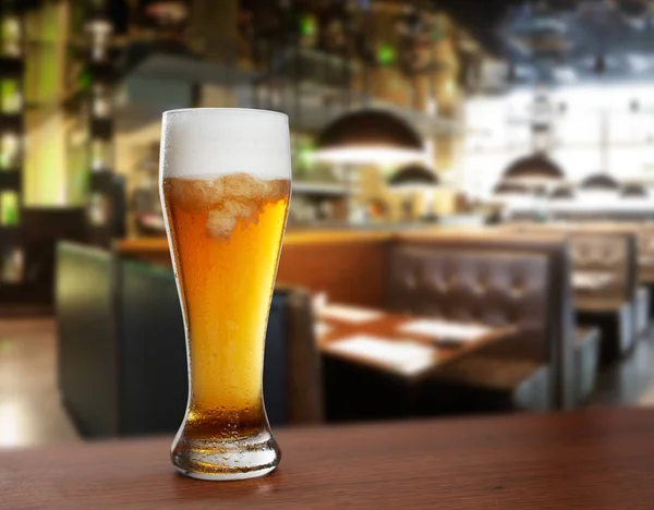 cold glass with beer on the background of bar.