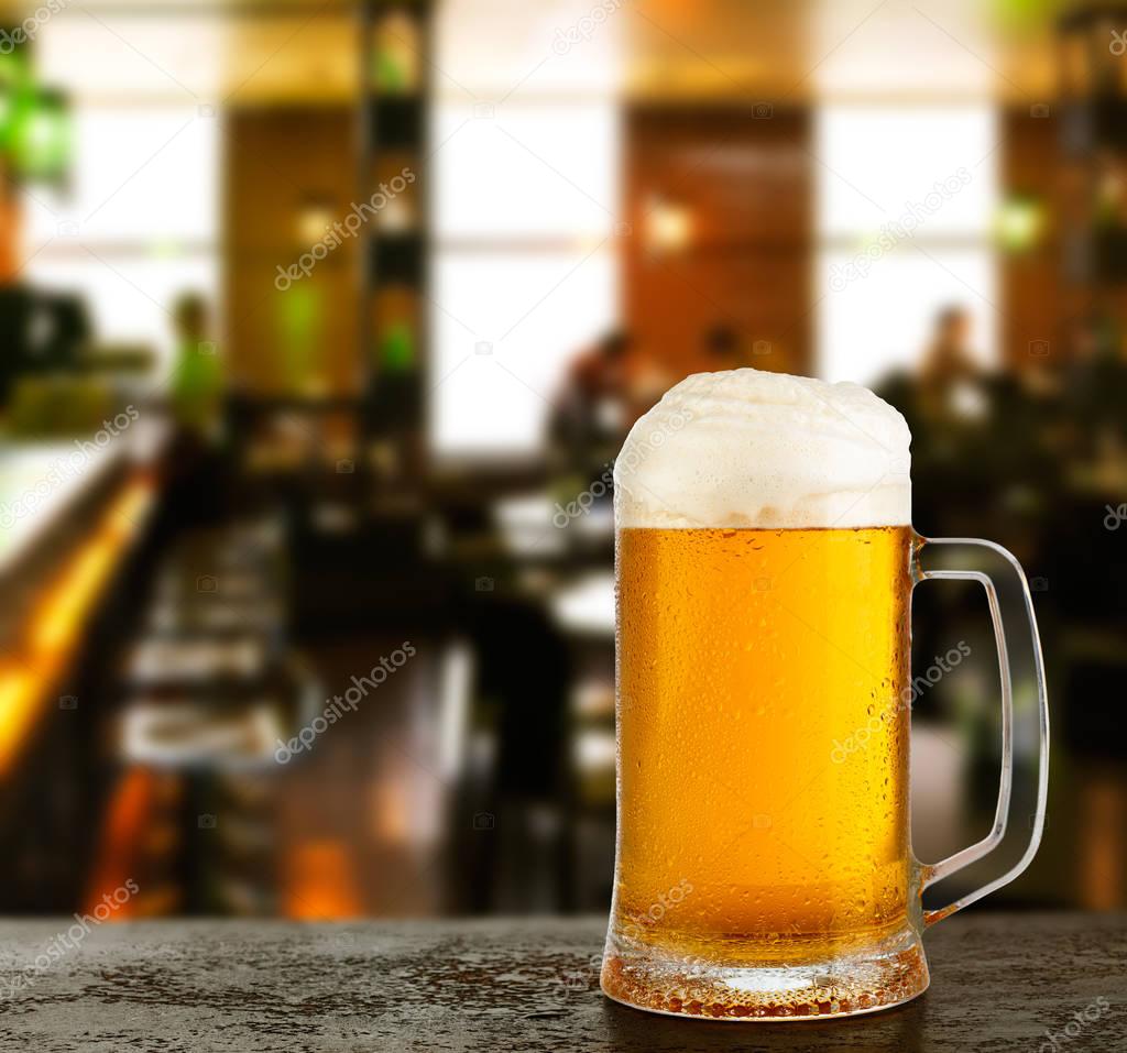 Mug with beer on the background of bar.