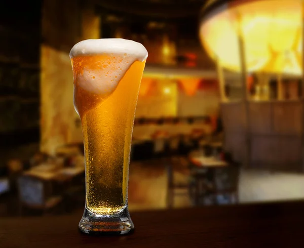 cold glass with beer on the background of bar.