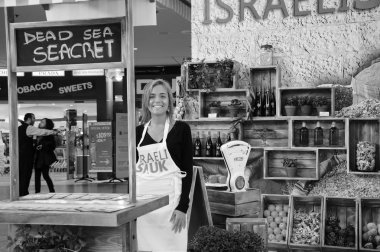 Tel Aviv, İsrail - 26 Şubat 2014: tanımlanamayan satıcı onların gidiş Ben Gurion Uluslararası Havaalanı Duty Free mağazaları alanda bekleyen turistler için tipik İsrail ürünleri satan. Siyah ve beyaz fotoğraf.