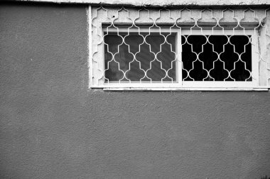 Sıva dokulu duvar üstünde a ızgara ve Sivrisinek perde ile küçük pencere. Beerşeba, İsrail. Yaşlı fotoğraf. Siyah ve beyaz.