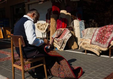 Tel Aviv-Yafa, İsrail-18 Şubat 2014: tamir ve bit pazarı, onun mağazasında renkli Doğu Halı satan tanımlanamayan üst düzey satıcı. Yüksek kontrast aydınlatma.