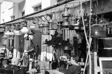 Tel Aviv-Yafa, İsrail - 18 Şubat 2014: Satıcıları ikinci el deposunun istemcileri için beklerken çay iç. Jaffa bit pazarı turistler ve yerliler için popüler konumlar olduğunu. Siyah ve beyaz fotoğraf.