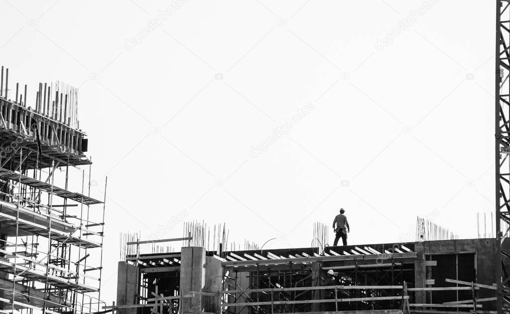 Scaffolding at the construction site of a new building. Construction site background. Aged photo. Black and white.