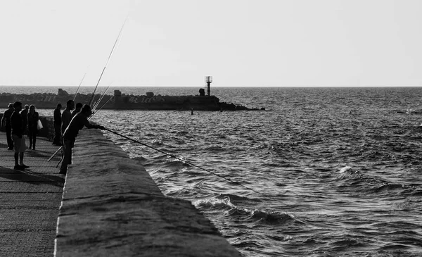 Tel Aviv-Yafa, İsrail-18 Şubat 2014: Silhouettes balıkçıların eski Jaffa port yakınındaki gün batımında Balık tutma. — Stok fotoğraf