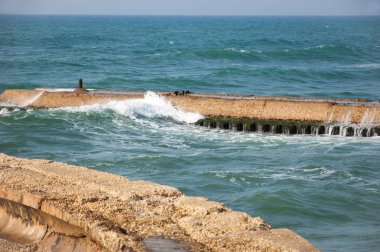 Dalgalar eski çimento kırma suyuna çarpıyor. Tel Aviv eski limanı, İsrail. Soyut kompozisyon.