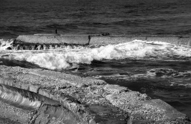 Eski çimento dalgakıran üzerinde çökmesini dalga. Tel Aviv eski liman (İsrail). Soyut Kompozisyon. Seçici odak iki dalgakıranlar arasında dalga. Siyah ve beyaz.