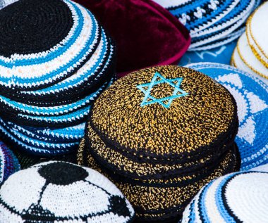 Kipa ile mavi Magen David (Davut yıldızı) ve diğer Yarmulkes Jerusalem (İsrail) pazarda satışa sarı. Portre. Seçici odak Magen David üst köşesinde. Yahudi arka plan