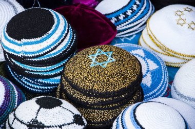 Kipa ile mavi Magen David (Davut yıldızı) ve diğer Yarmulkes Jerusalem (İsrail) pazarda satışa sarı. Portre. Seçici odak Magen David üst köşesinde. Yahudi arka plan