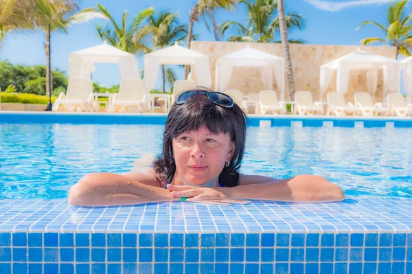 Mujer está acostada cerca de la piscina —  Fotos de Stock