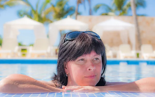 Donna è sdraiata vicino alla piscina — Foto Stock