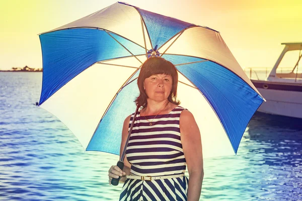 Morena mujer con un paraguas de playa —  Fotos de Stock