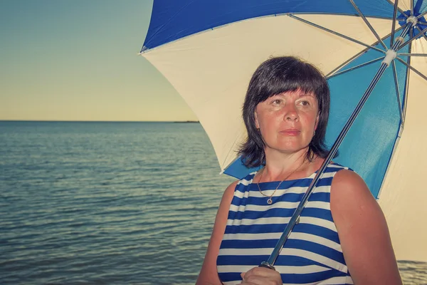 Brunette woman with a beach umbrella — Stock Photo, Image