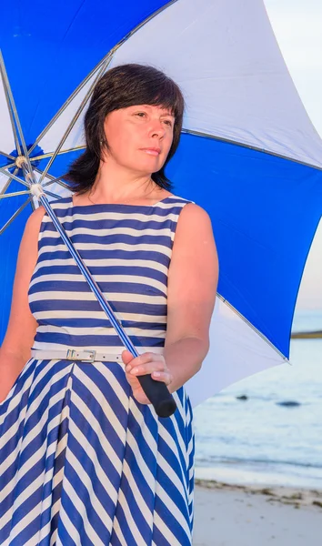 Morena mujer con un paraguas de playa —  Fotos de Stock