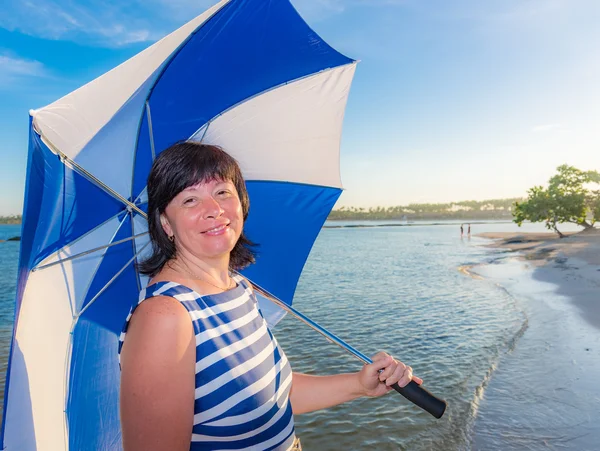 Morena mujer con un paraguas de playa — Foto de Stock