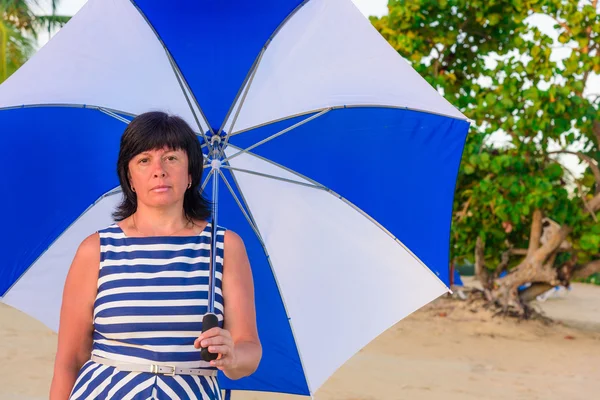 Bir plaj şemsiyesi ile esmer kadın — Stok fotoğraf