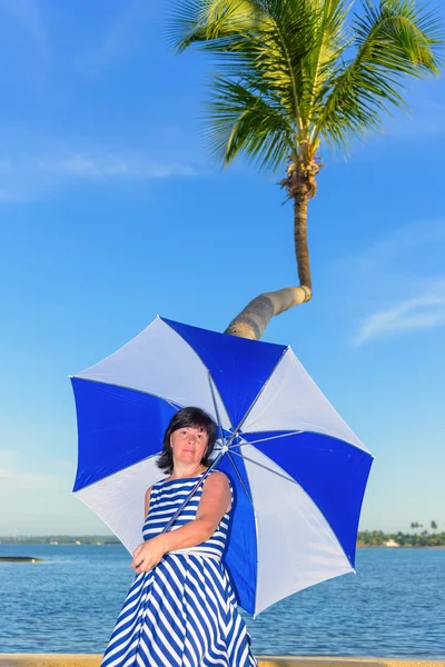 Mulher morena com um guarda-chuva de praia — Fotografia de Stock