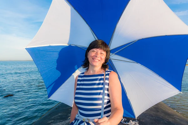 Mulher morena com um guarda-chuva de praia — Fotografia de Stock