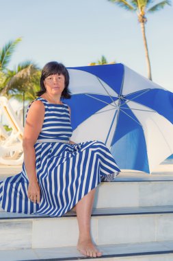 bir plaj şemsiyesi ile esmer kadın