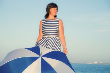 bir plaj şemsiyesi ile esmer kadın