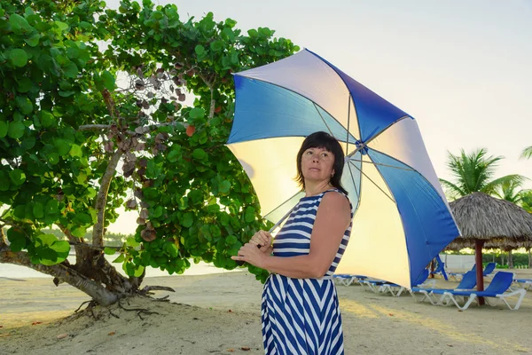 Morena mujer con un paraguas de playa —  Fotos de Stock