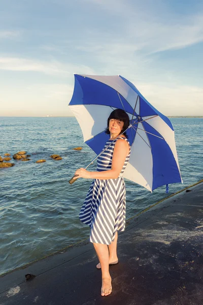 Mulher morena com um guarda-chuva de praia — Fotografia de Stock