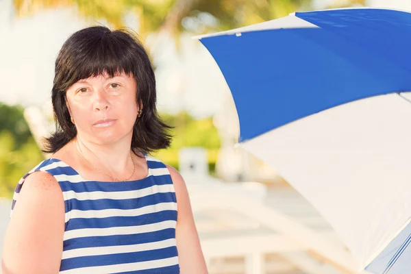 Bir plaj şemsiyesi ile esmer kadın — Stok fotoğraf