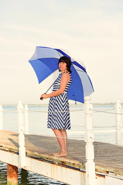 Mulher morena com um guarda-chuva de praia — Fotografia de Stock